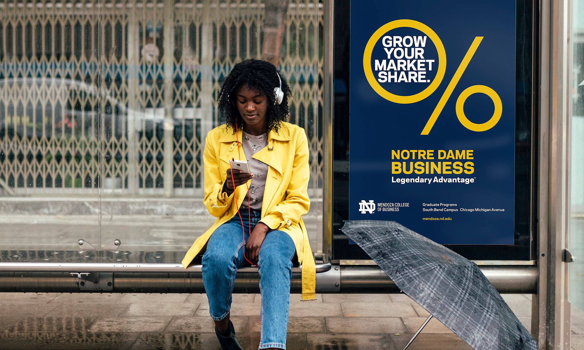 Young woman w umbrella sitting at bus stop by ND Mendoza Grow Your Market Share sign
