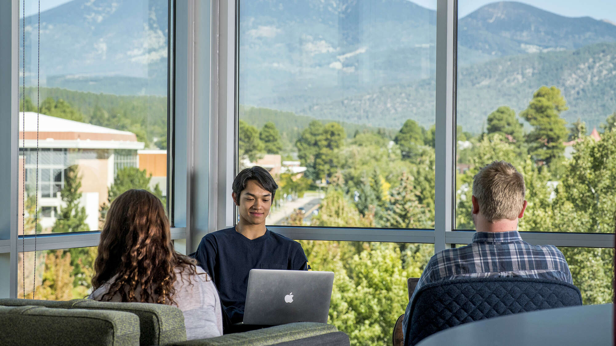 3 students studying with view of mountains through large windows
